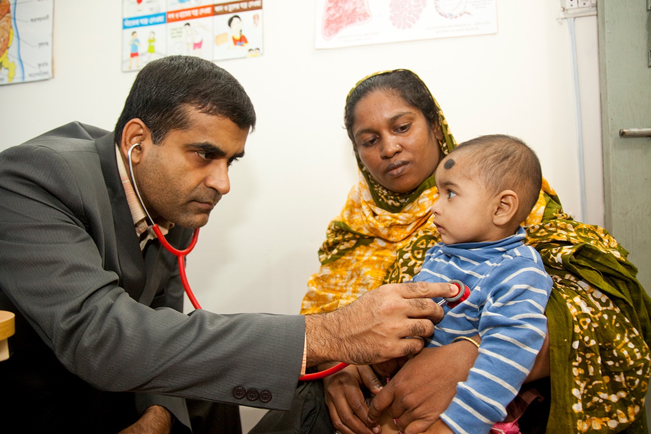 A doctor examines a child in Bangladesh.