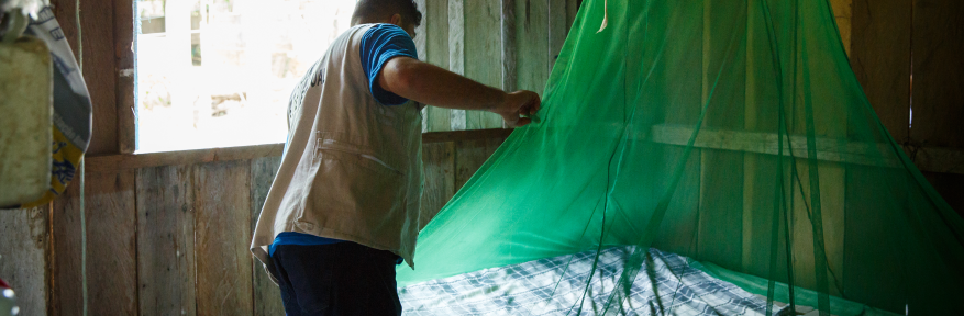 A community health worker delivers a new insecticide-treated bed net to a resident in a rural area of Manaus, Brazil.