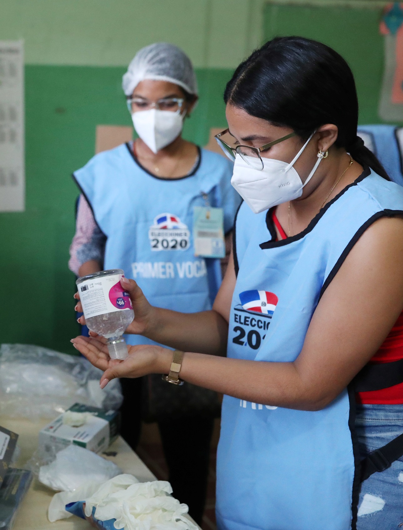 Electoral workers wearing protective masks use hand sanitizer during the outbreak of the coronavirus disease (COVID-19), in Santiago, Dominican Republic July 5, 2020. 