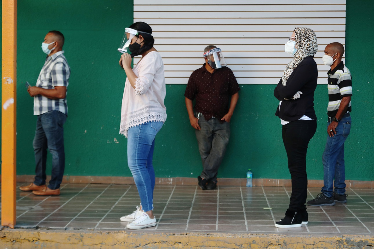 People wearing protective masks stand in line to cast their votes in the general election during the outbreak of the coronavirus disease (COVID-19), in Santiago, Dominican Republic July 5, 2020. 