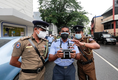 A Sri Lanka Air Force member, along with police officers, controls a drone camera to monitor and apprehend quarantine regulation violators in a highly populated residential area, during a lockdown due to the increasing numbers of daily coronavirus disease (COVID-19) cases, in Colombo, Sri Lanka May 23, 2021.
