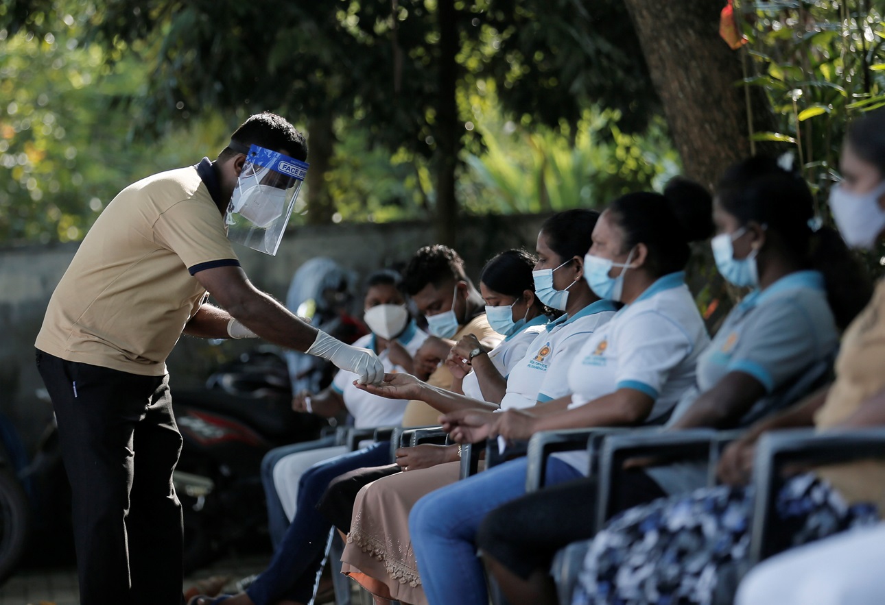 Health officials wearing protective face masks receive numbers for their turn during a simulation exercise for the coronavirus disease (COVID-19) vaccination in the Piliyandala suburb, south of Colombo, Sri Lanka January 23, 2021.