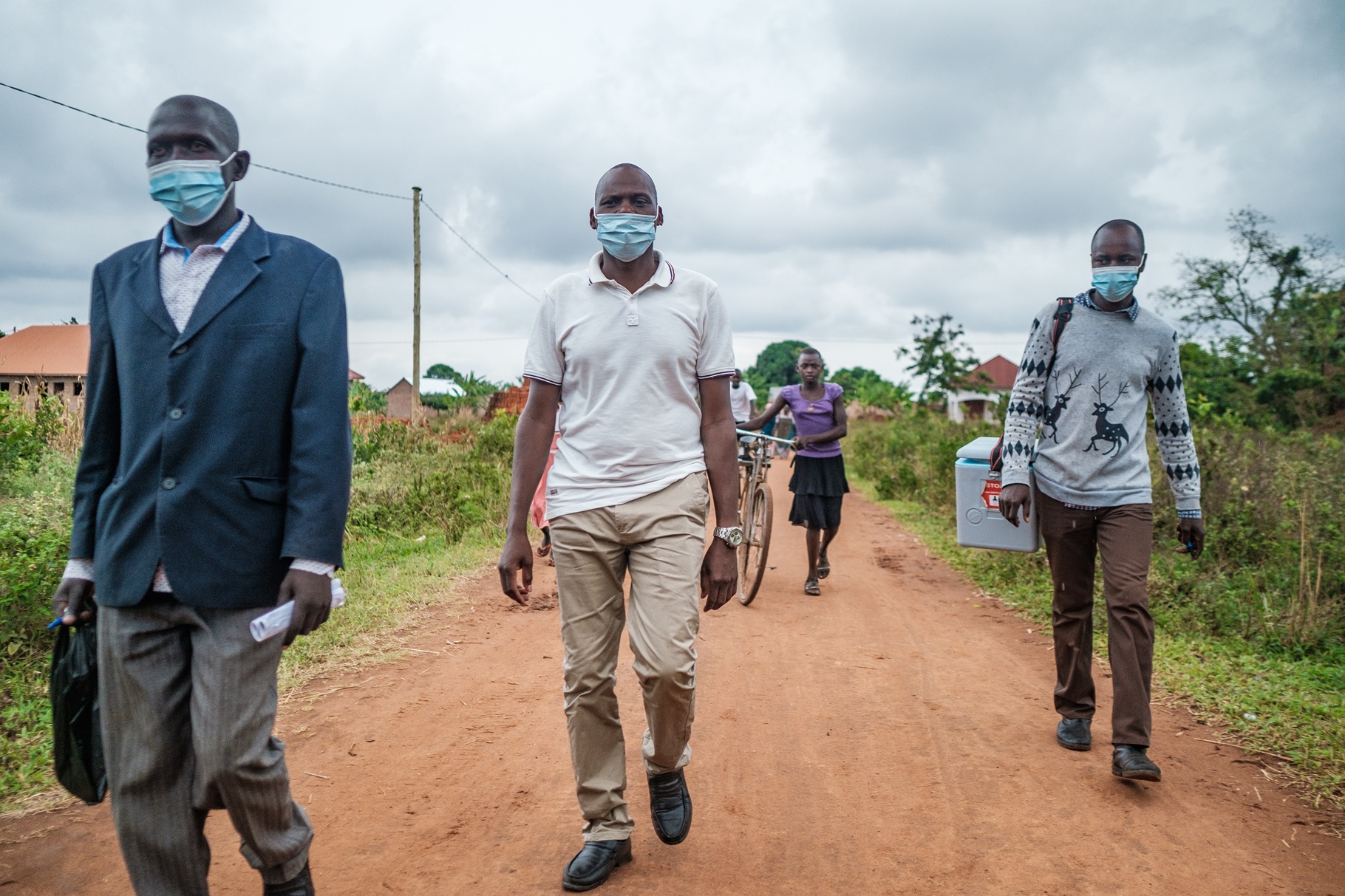 Community health workers Ronald Tenywa (c), Muwangala Herbert (r) and David Kiirya (l) during a polio vaccination campaigns in Buyende, Uganda on January 17, 2022. 