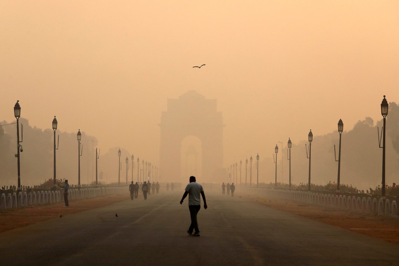A man walks in front of the India Gate shrouded in smog in New Delhi.