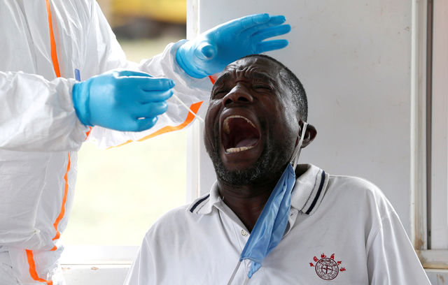 A health worker swabs a truck driver at the Namanga border crossing between Kenya and Tanzania.