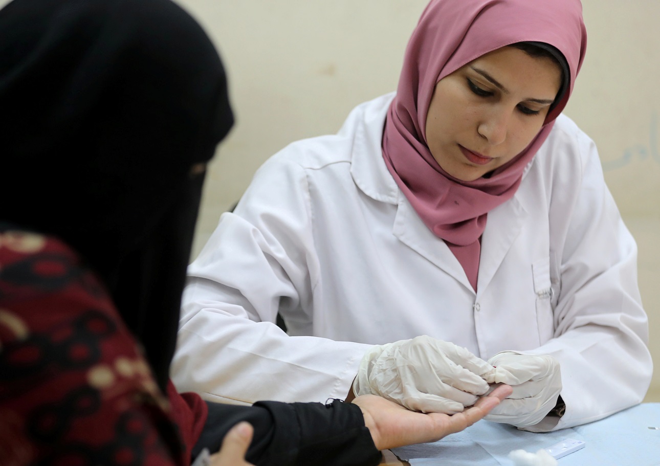 An Egyptian doctor tests a woman for hepatitis C.