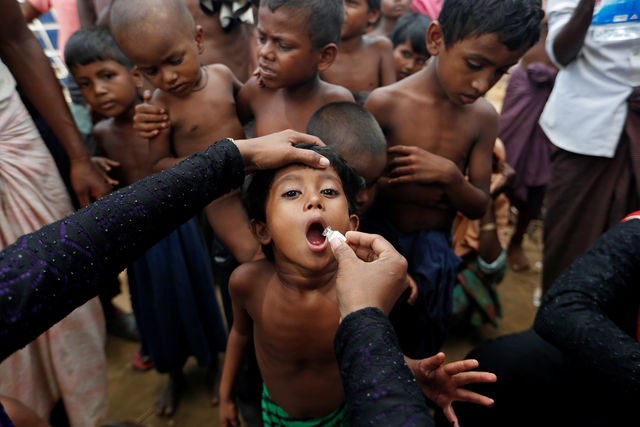 A Rohingya refugee receives an oral cholera vaccine distributed by the WHO