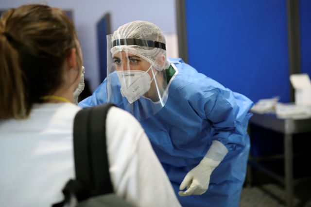 A health worker tests an arriving passenger at the Eleftherios Venizelos International Airport in Athens in 2020.