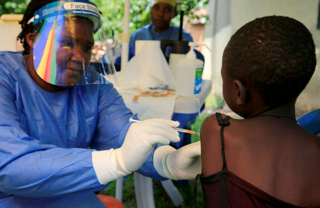 A Ugandan health worker administers an Ebola vaccine near the DRC border in June 2019.