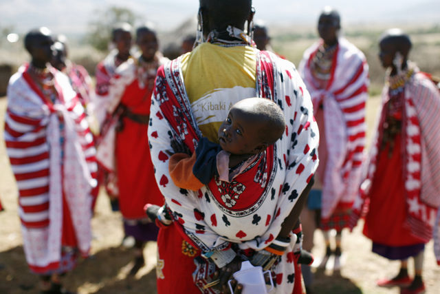 A Maasai woman in Kenya carries her baby.