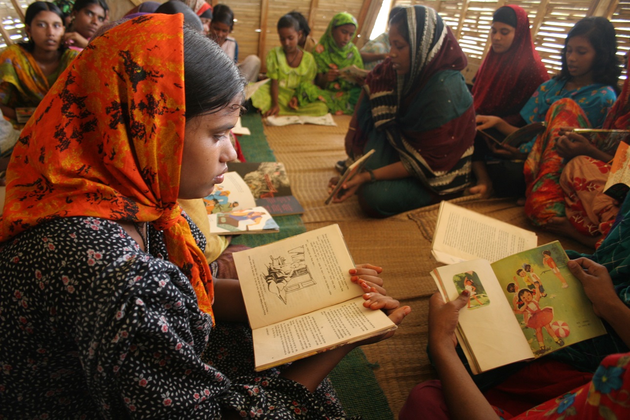 Women and girls looking at books on a boat converted to a library in the Rajshahi Division of Bangladesh.