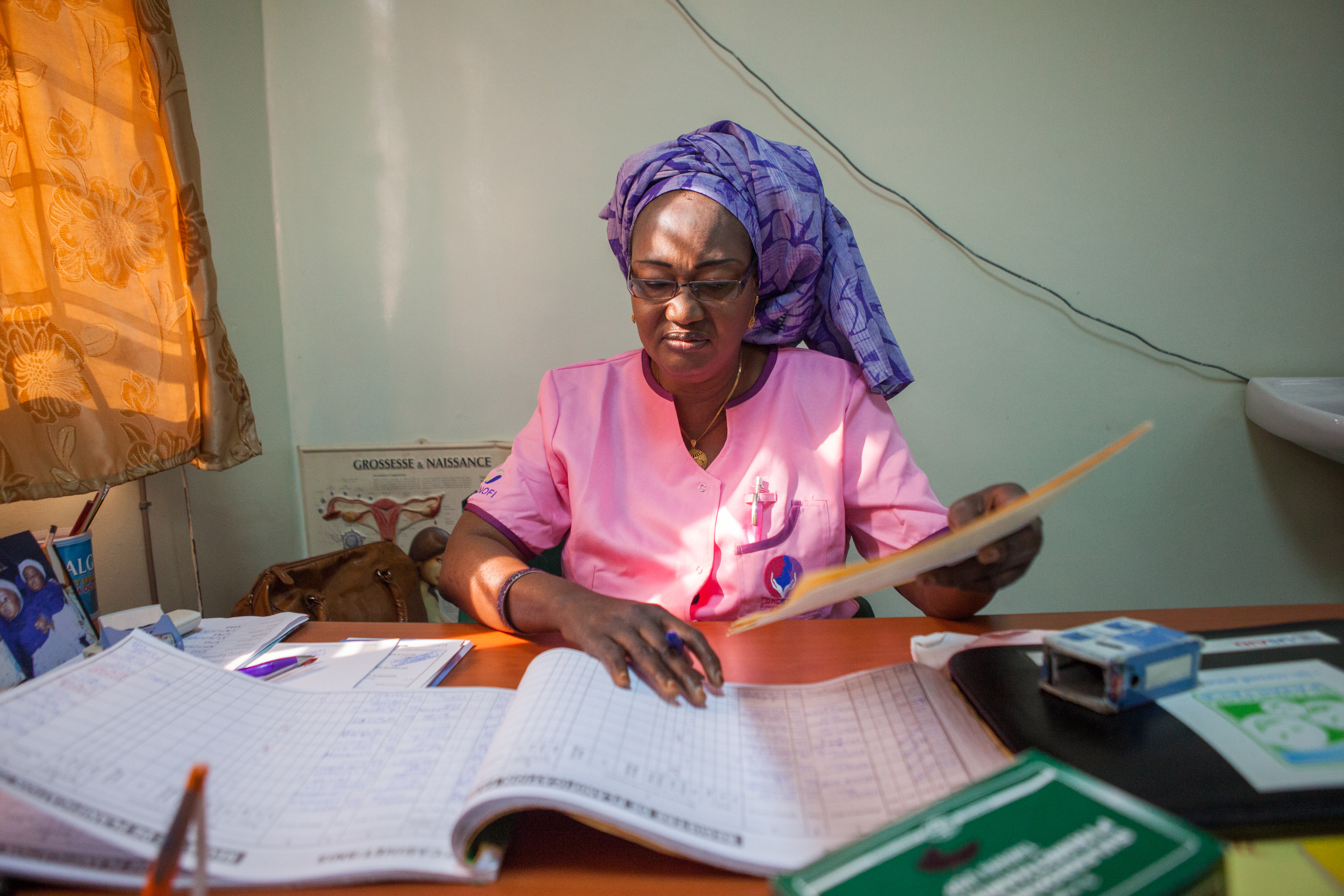 A midwife looks through records at a Health Center in Senegal.