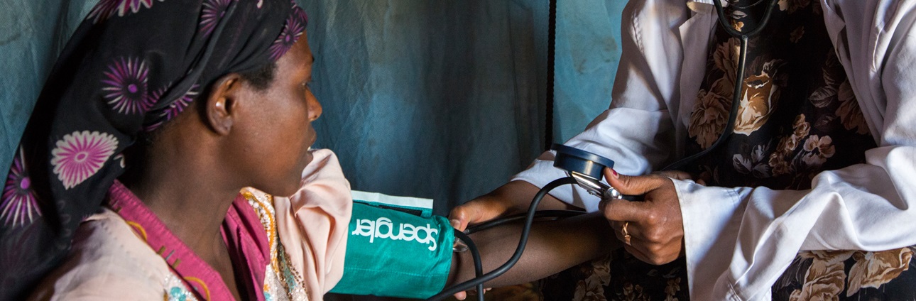 A health extension worker measures a young mother's blood pressure during a house call in Ethiopia.
