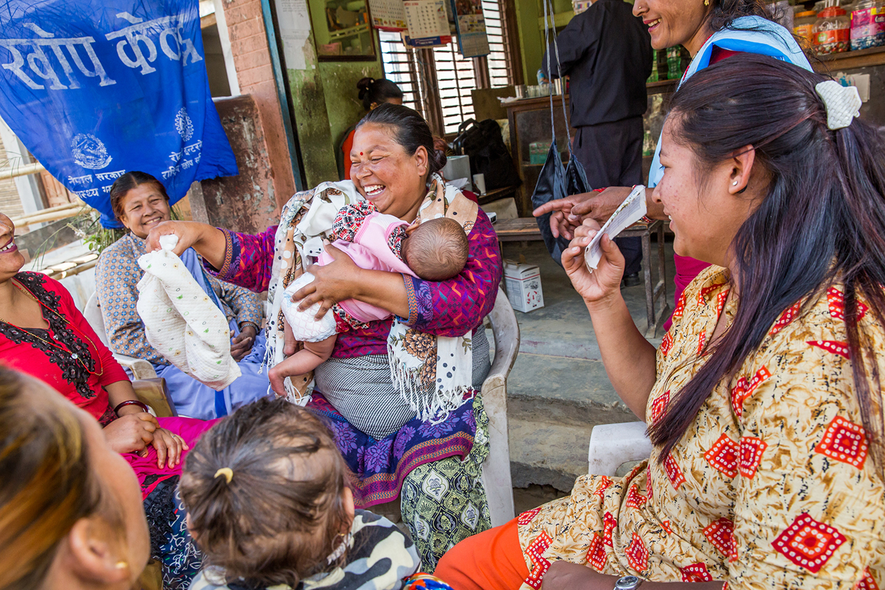 A community health volunteer teaches new mothers about health care.