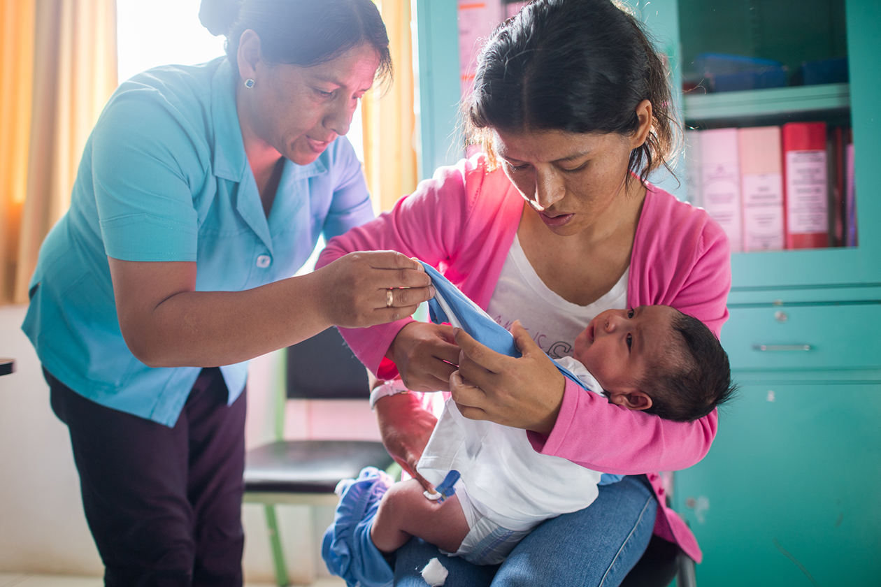 A healthcare worker in Peru discusses an infant’s health with the mother.