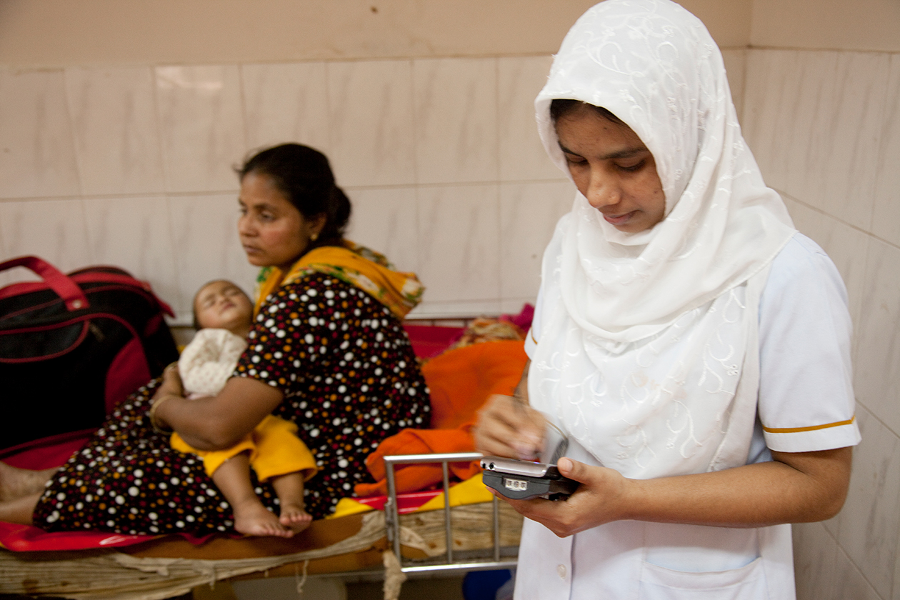 A nursing assistant records patient observations at ICDDR, B Dhaka Hospital in Bangladesh.