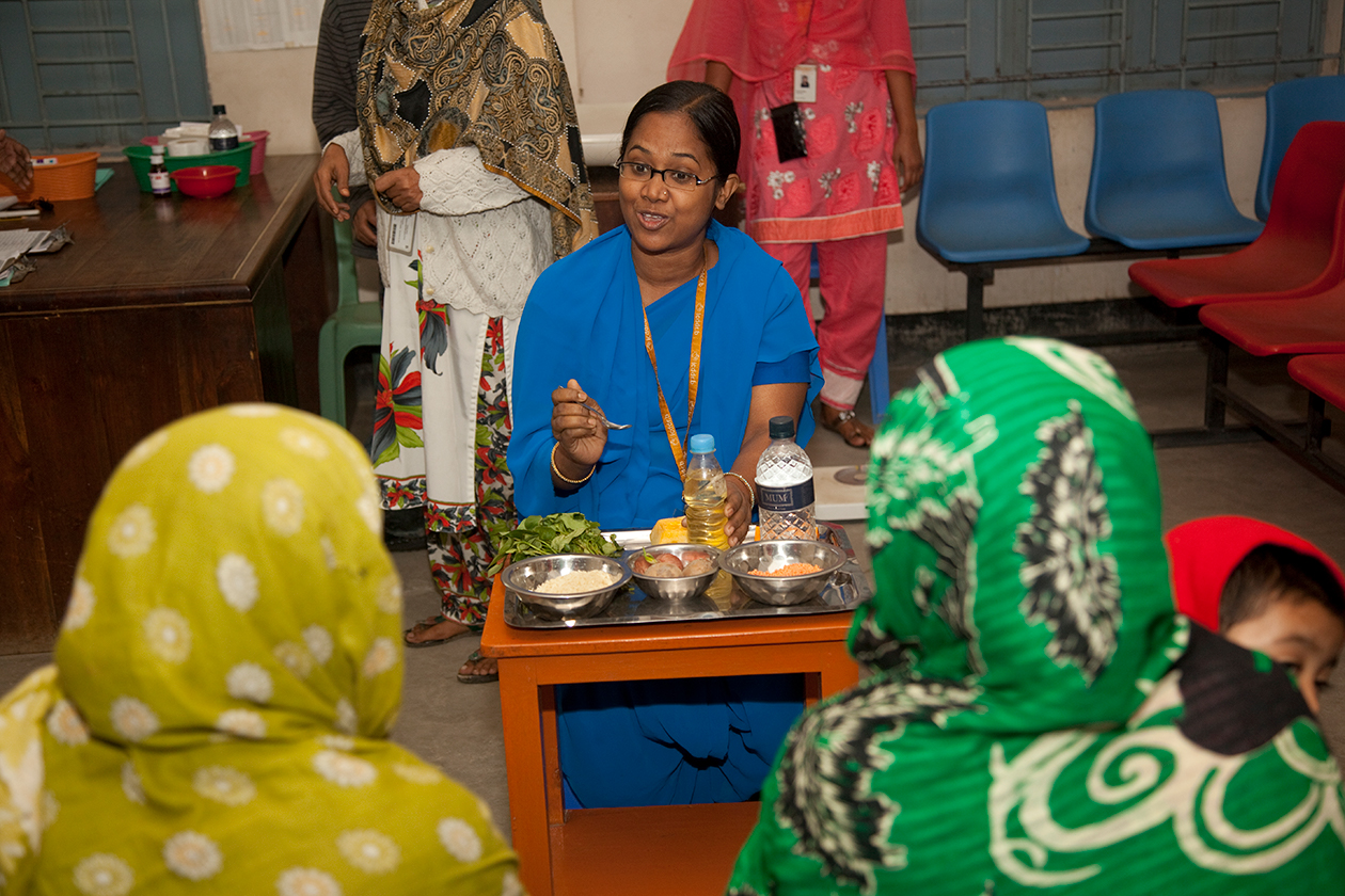 A health worker talks to mothers about nutrition information at the Kamalapur Urban Surveillance Site Field Office and Clinic in Bangladesh.