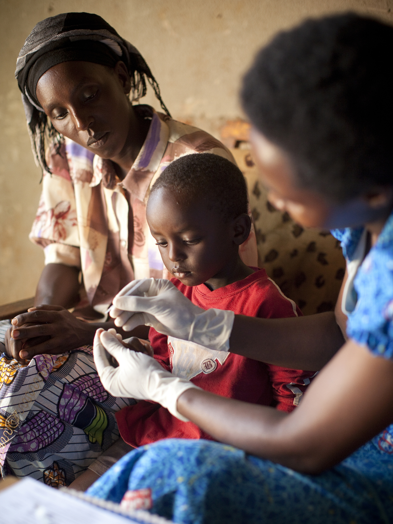 A community health worker administers a malaria test on a four-year-old boy in Rumyongza, Rwanda