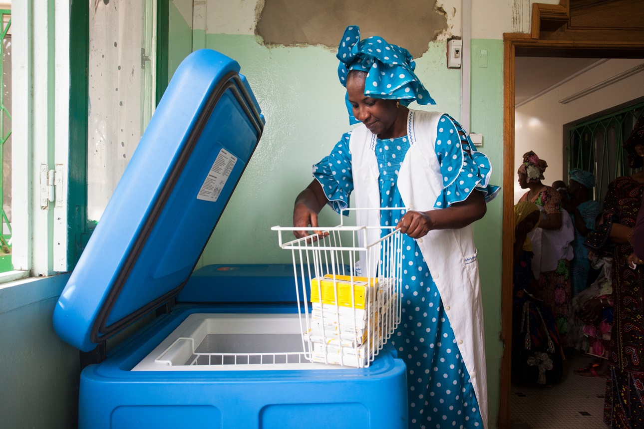 A nurse verifying the stock of vaccines in a cold chain fridge in Dakar, Senegal