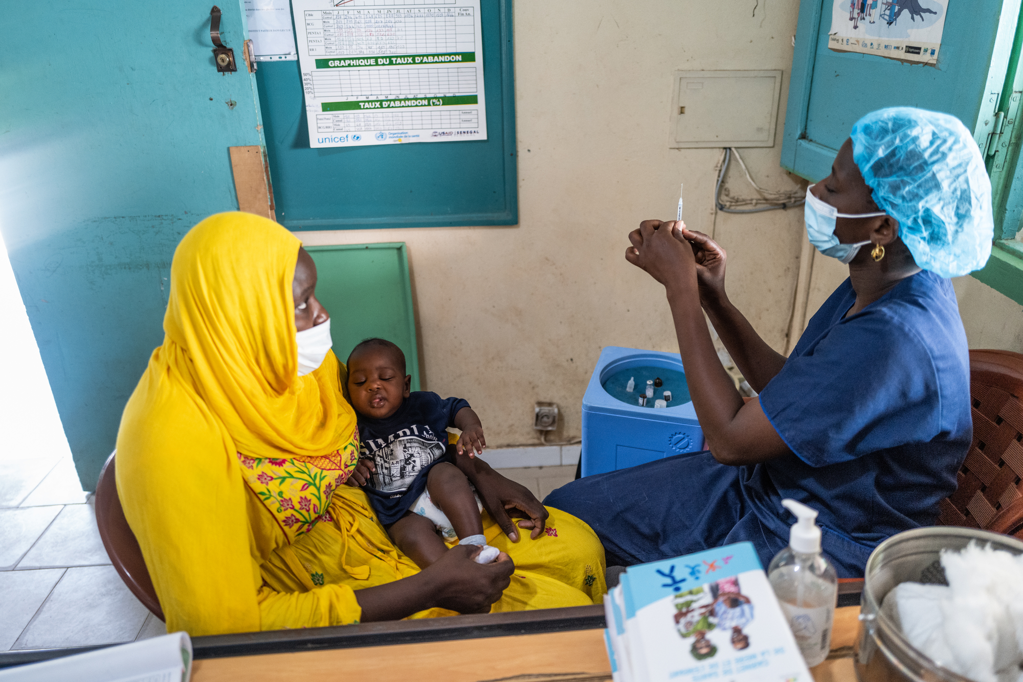 A son receives the pentavalent vaccine from nurse in Dakar, Senegal 